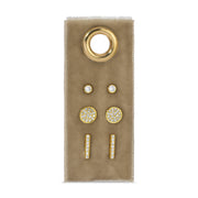 Set of gold and diamond earrings on a beige card with a white background