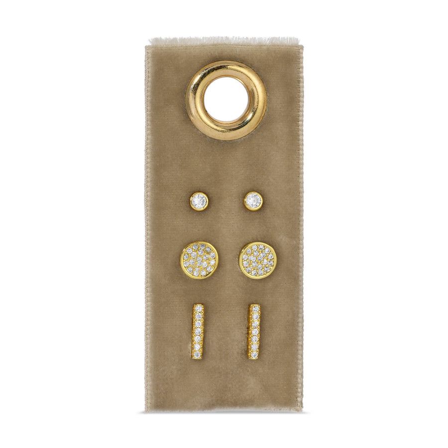 Set of gold and diamond earrings on a beige card with a white background