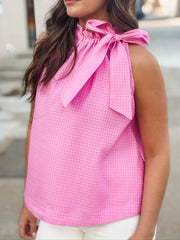 Textured pink top featuring a feminine bow tie neckline and relaxed fit