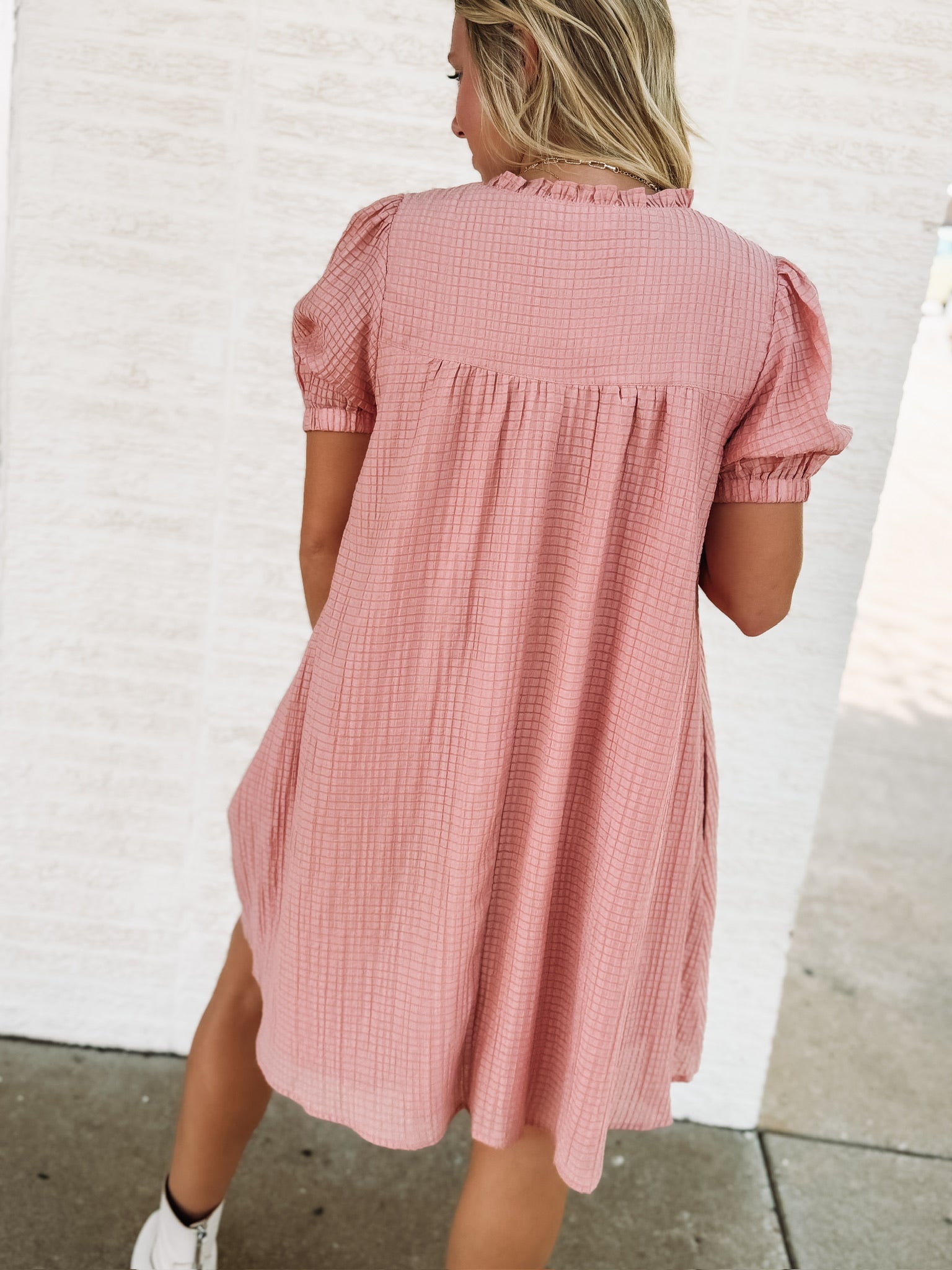 Dusty pink short sleeve baby dol dress with white bow detailing.