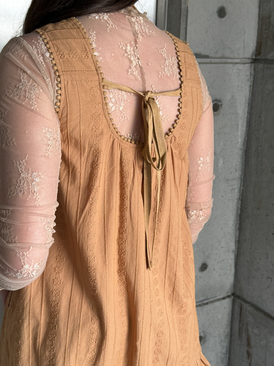 Camel colored embroidered sleeveless mini dress with ruffle hem and pleated detailing.