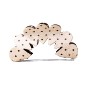 Decorative hair claw with polka dot design on a cream background
