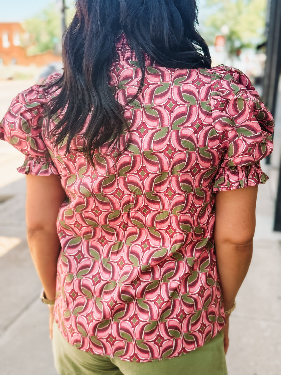 Blouse with a band collar with a wine, pink, and olive colored geometric print