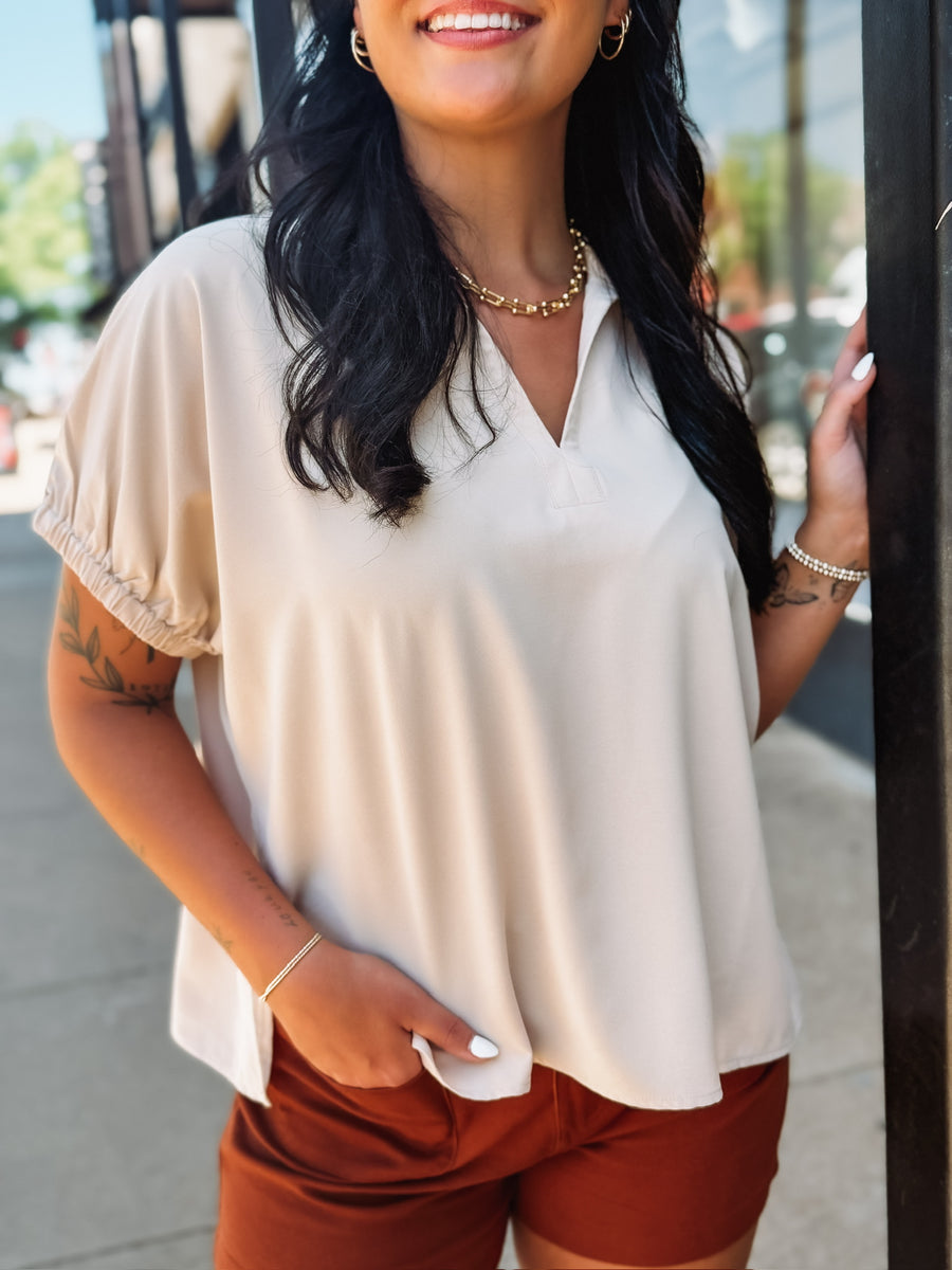 Lightweight collared blouse with elastic short sleeves and a relaxed fit.