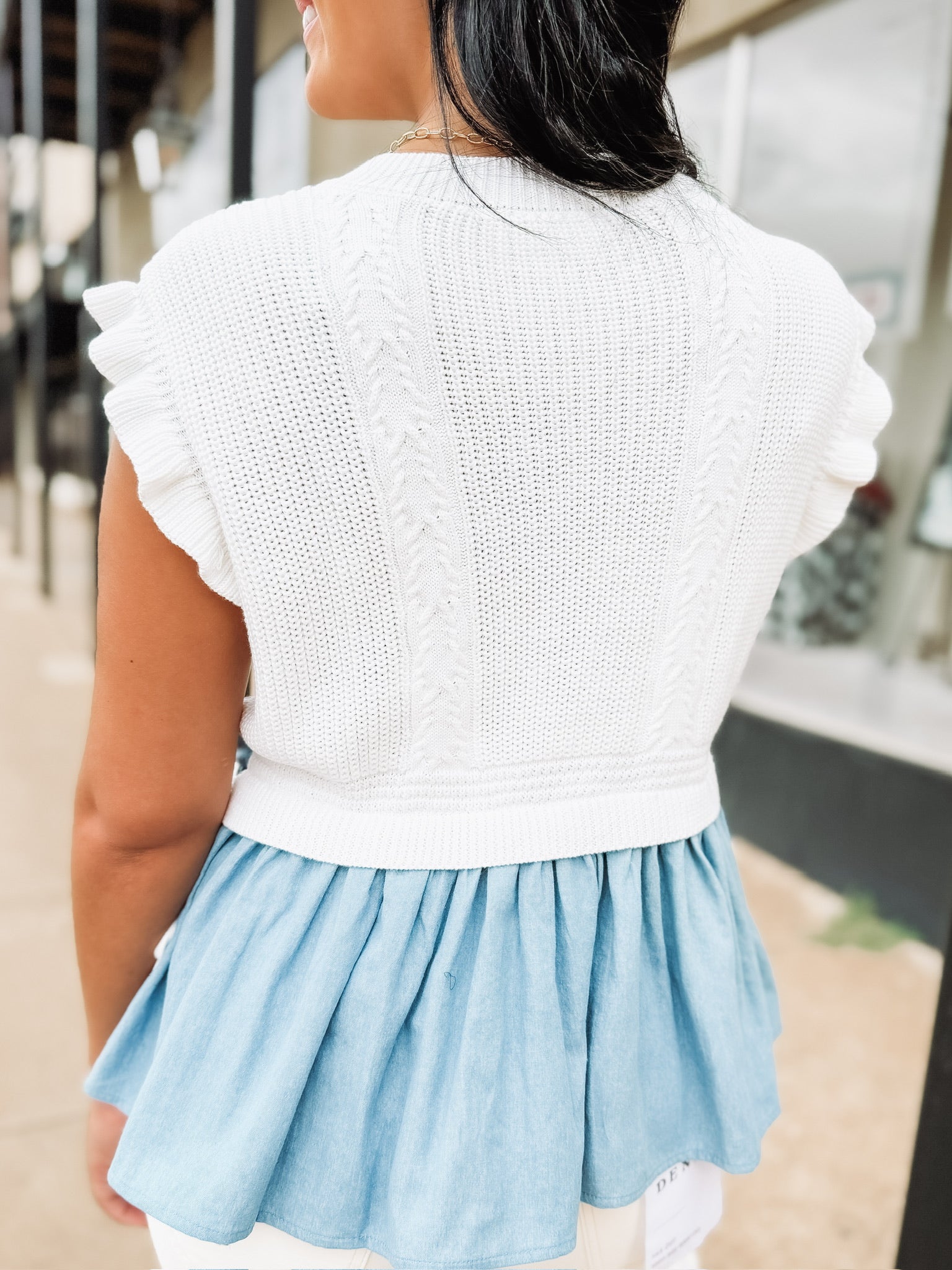 Soft knit short sleeve sweater with ruffle sleeves and peplum denim looking details with side bow detailing.