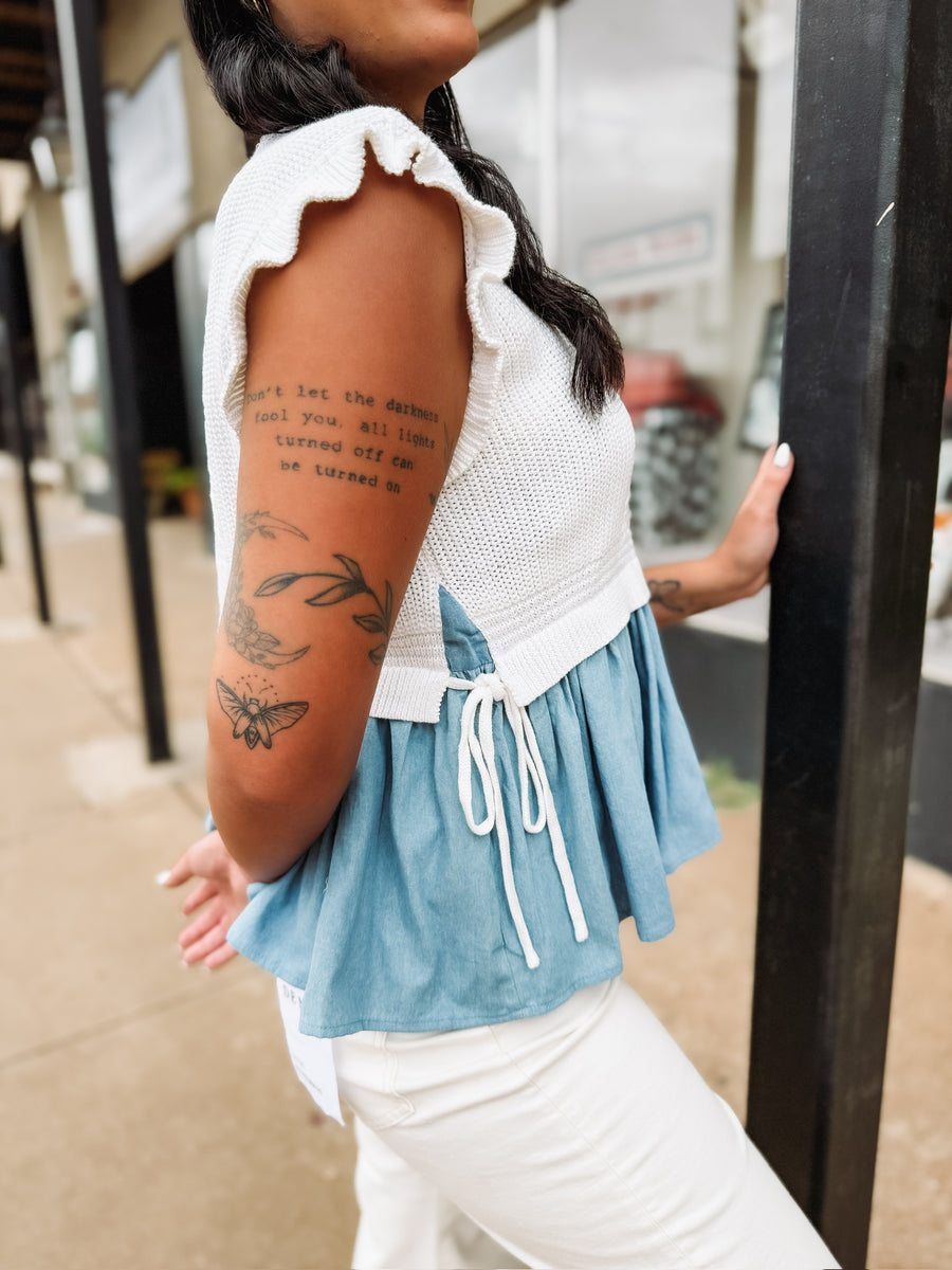 Soft knit short sleeve sweater with ruffle sleeves and peplum denim looking details with side bow detailing.