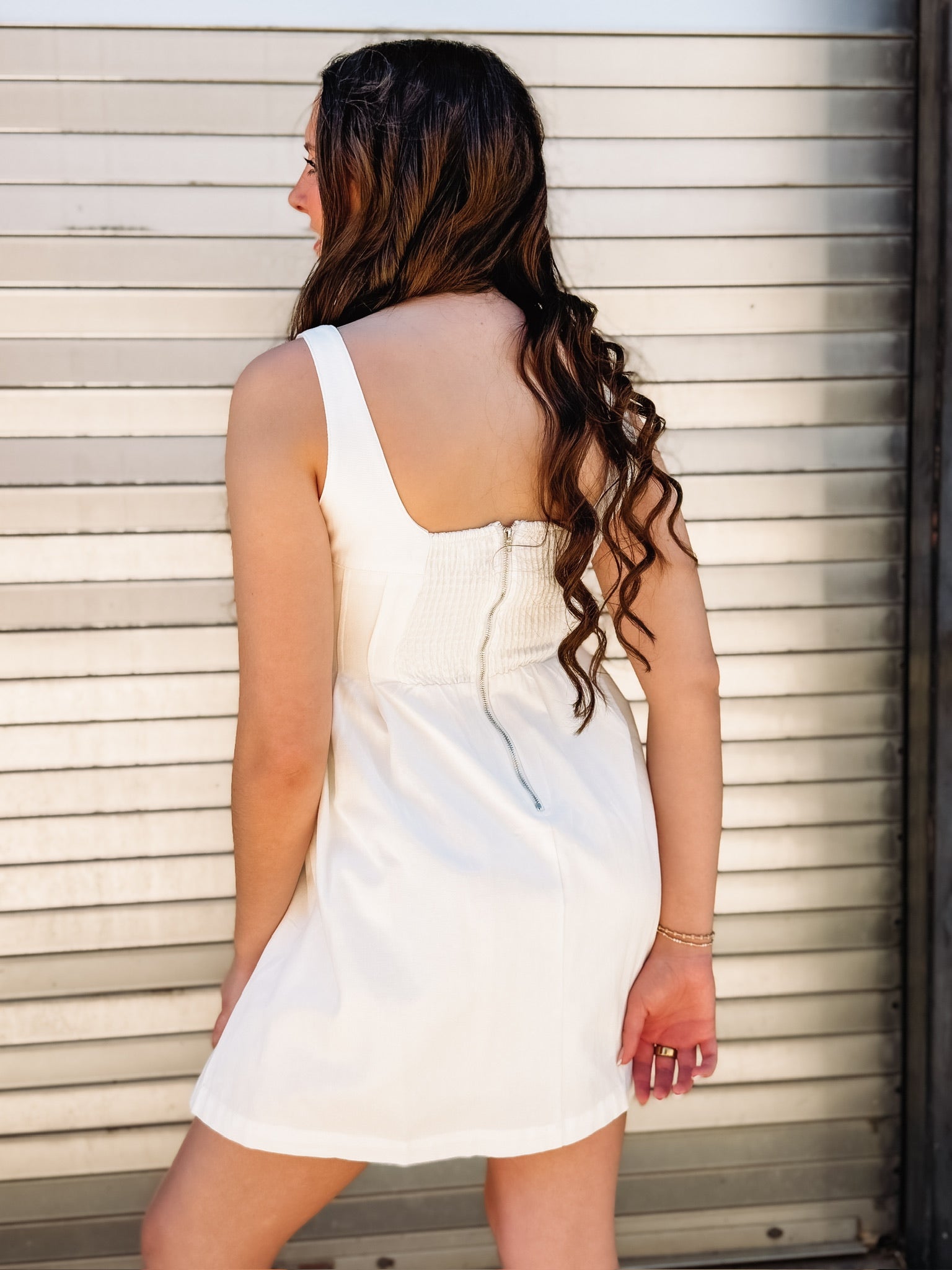 White sleeveless denim dress with a fit and flare fit and seaming detail down the bodice.