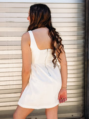 White sleeveless denim dress with a fit and flare fit and seaming detail down the bodice.