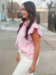 Pink ruffle sleeve pinstriped blouse with a ruffle neckline and a self tie detail.