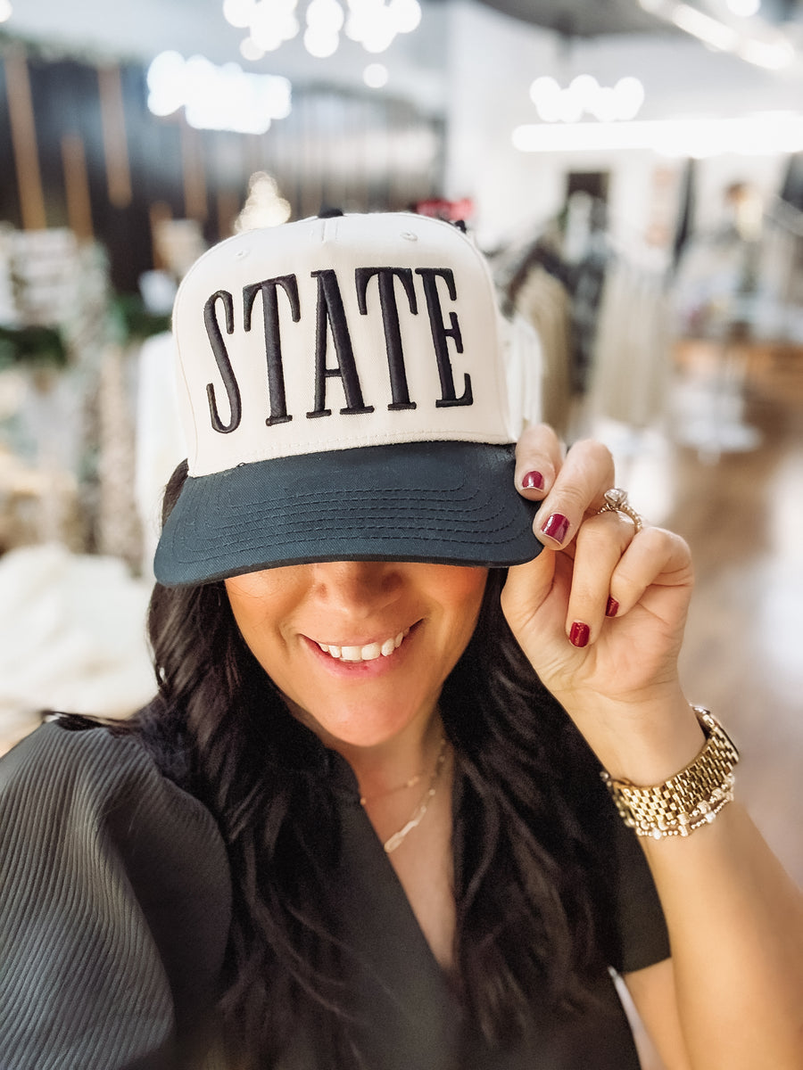 'STATE' on a black and khaki canvas hat.