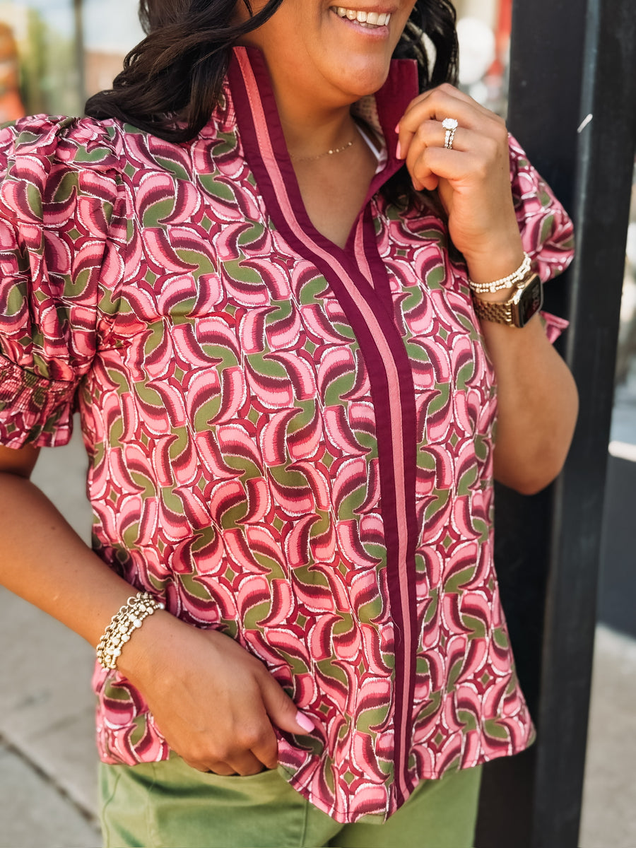 Blouse with a band collar with a wine, pink, and olive colored geometric print