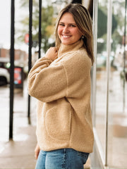 Tan sherpa quarter-zip pullover with front pockets.