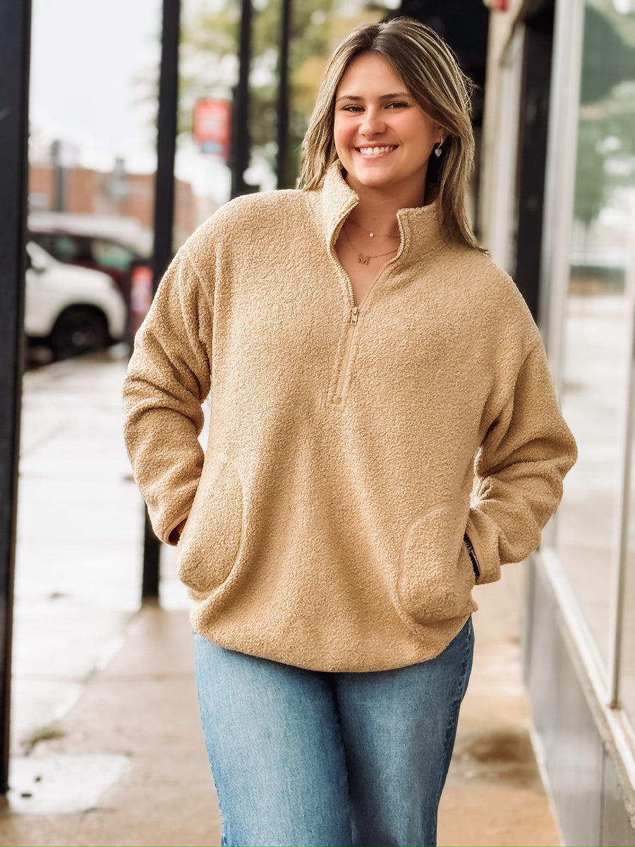 Tan sherpa quarter-zip pullover with front pockets.