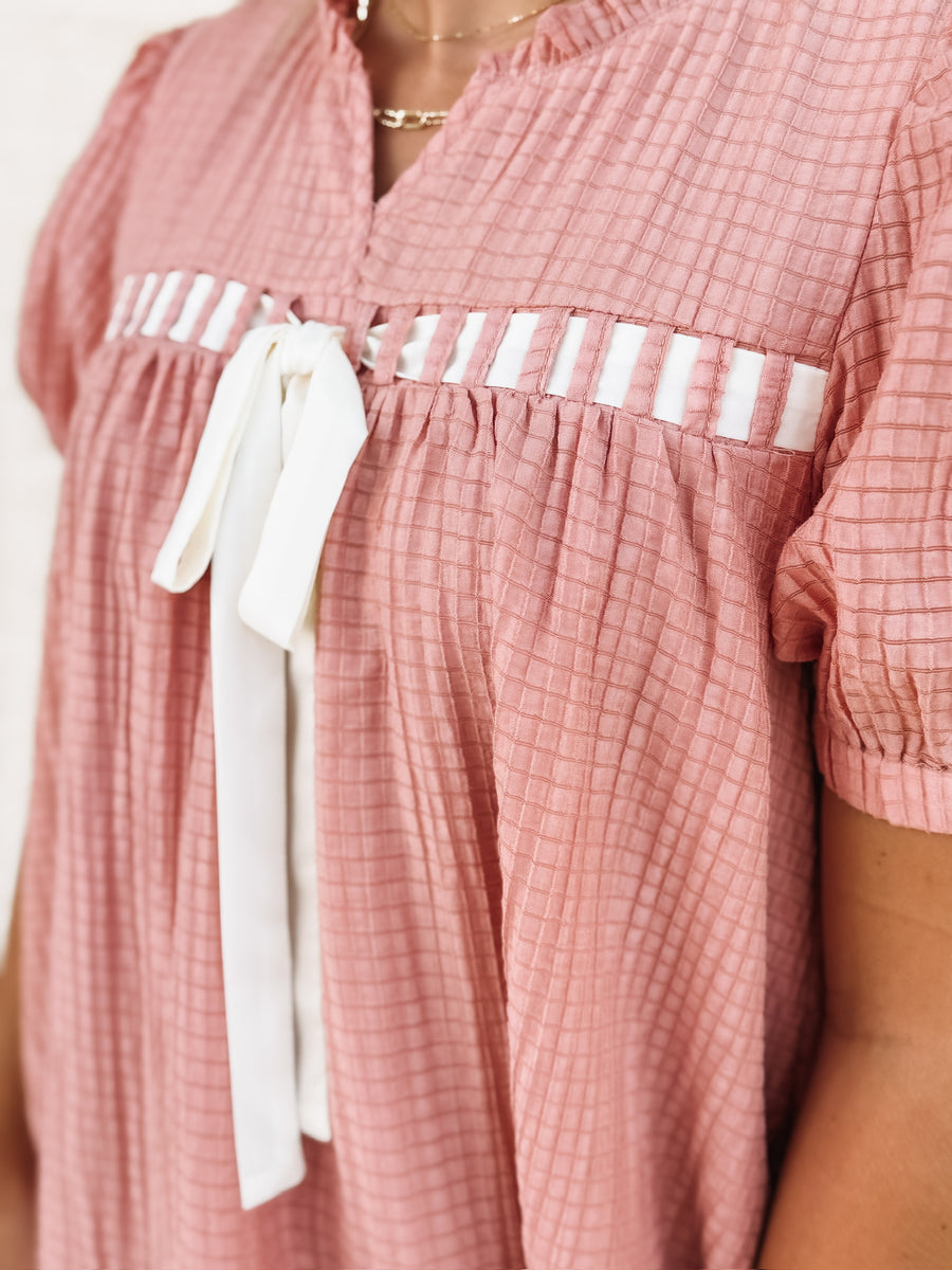  Dusty pink short sleeve baby dol dress with white bow detailing.