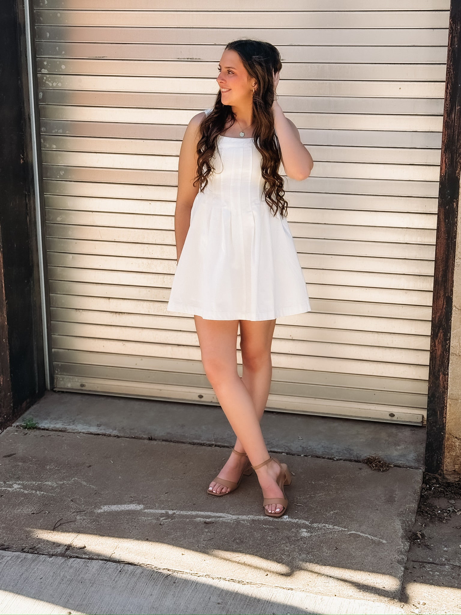 White sleeveless denim dress with a fit and flare fit and seaming detail down the bodice.