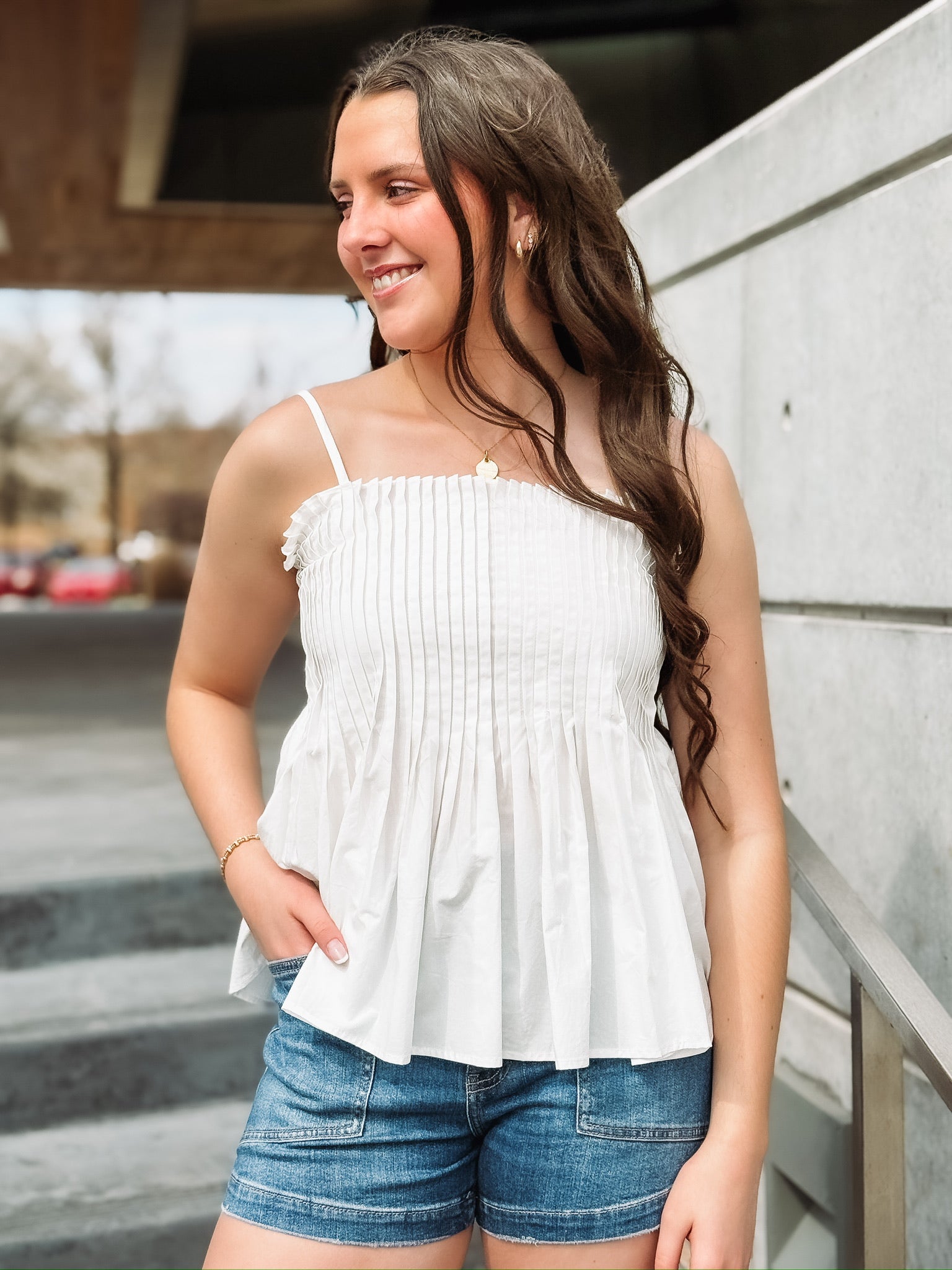 White pintuck spaghetti strap top with adjustable straps and a fit and flare look.