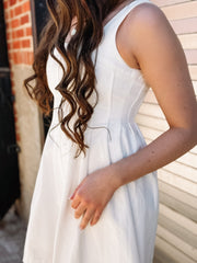 White sleeveless denim dress with a fit and flare fit and seaming detail down the bodice.