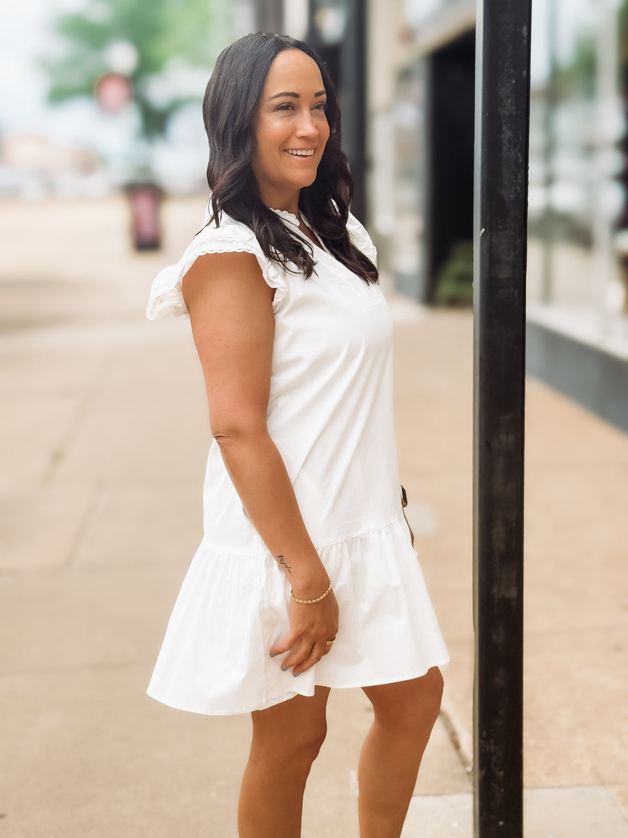 Woman in a white dress standing on a street