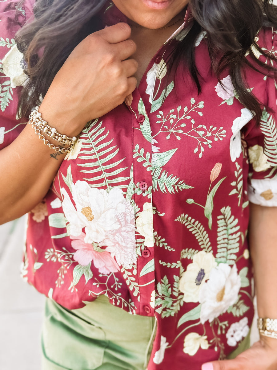 Wine-colored floral blouse with a ruffle neckline and button-up front