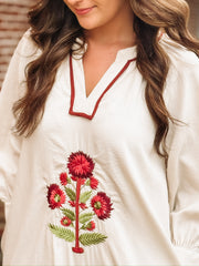Loose, ankle length cream dress with three quarter puff sleeves and a split neckline. The dress features bold red floral embroidery with green stems arranged vertically down the front. It has a relaxed, flowy silhouette with side slits at the hem. 