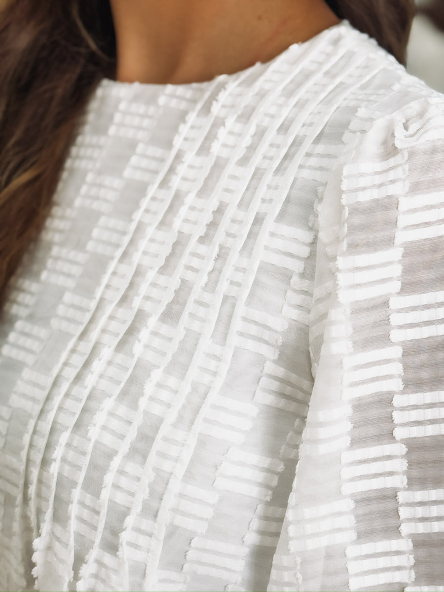 White long sleeve blouse with tonal checkered texture and shiver balloon sleeves.
