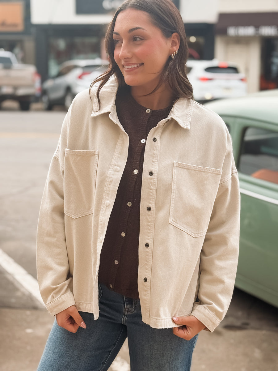 Woman wearing a beige jacket on a city street