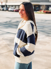 Woman wearing a blue and cream striped sweater in an urban setting
