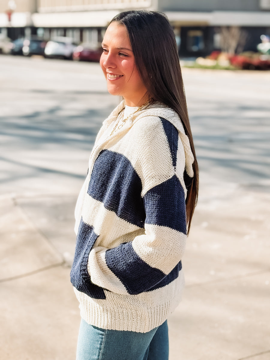 Woman wearing a blue and cream striped sweater in an urban setting