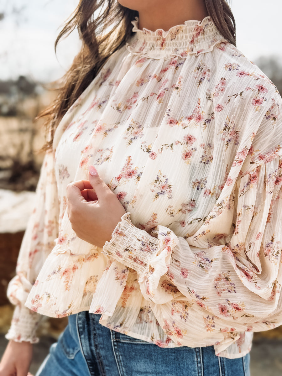 Floral blouse with ruffled sleeves worn by a person outdoors