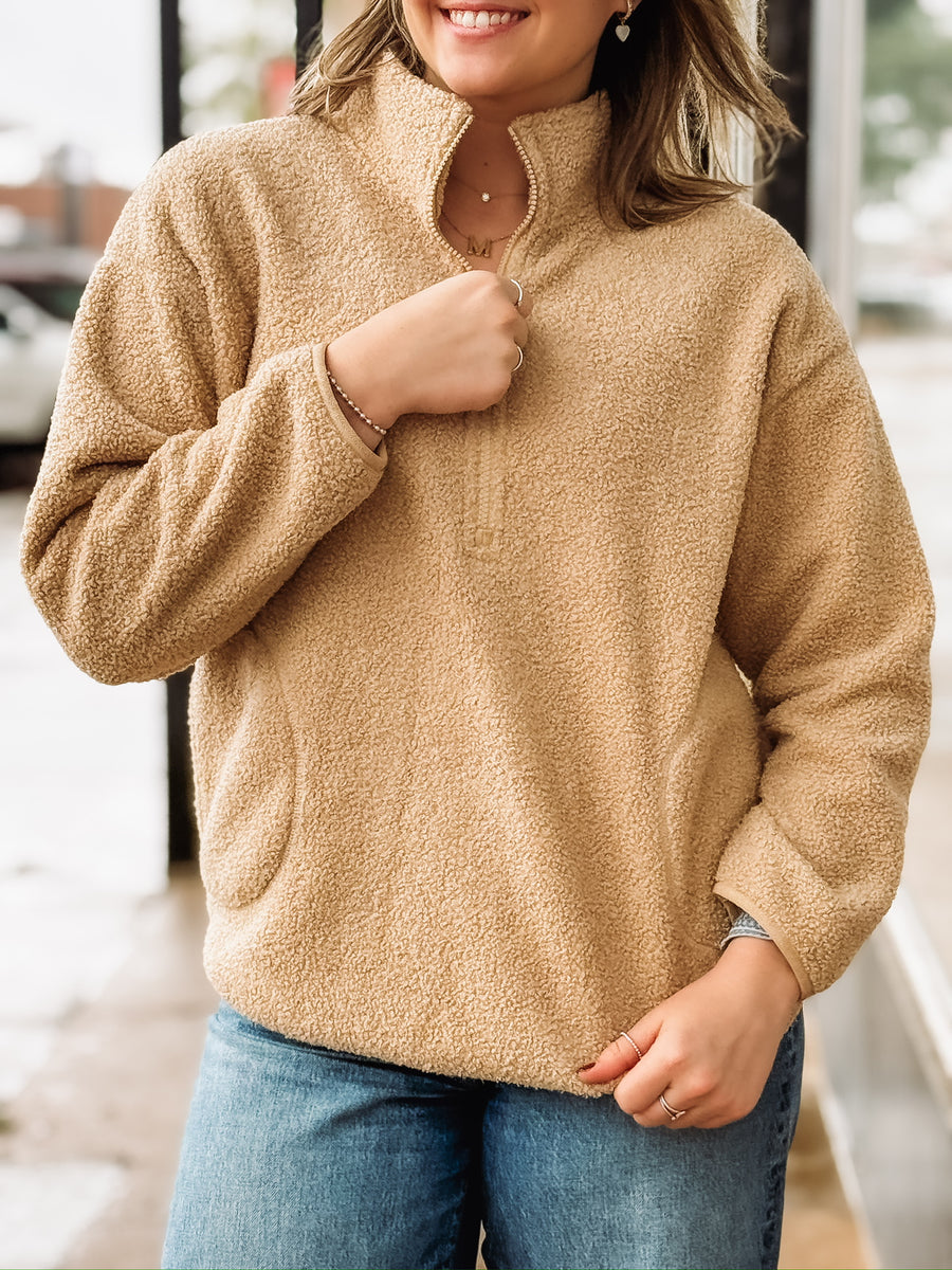 Tan sherpa quarter-zip pullover with front pockets.