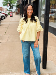 woman wearing yellow blouse on sidewalk